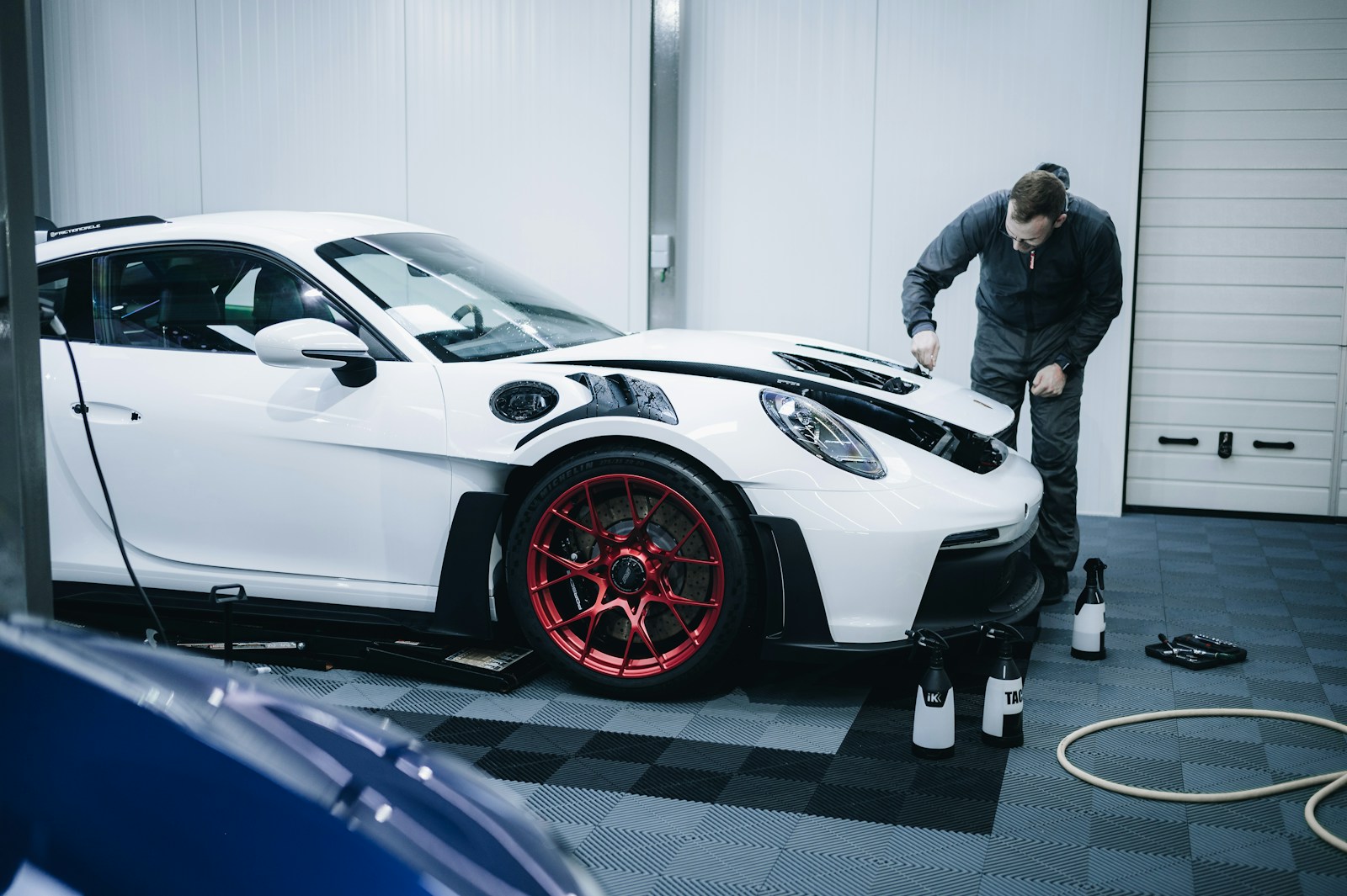 a man working on a white car in a garage